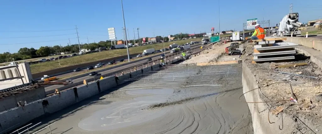 Workers installing engineered fill for roadway base